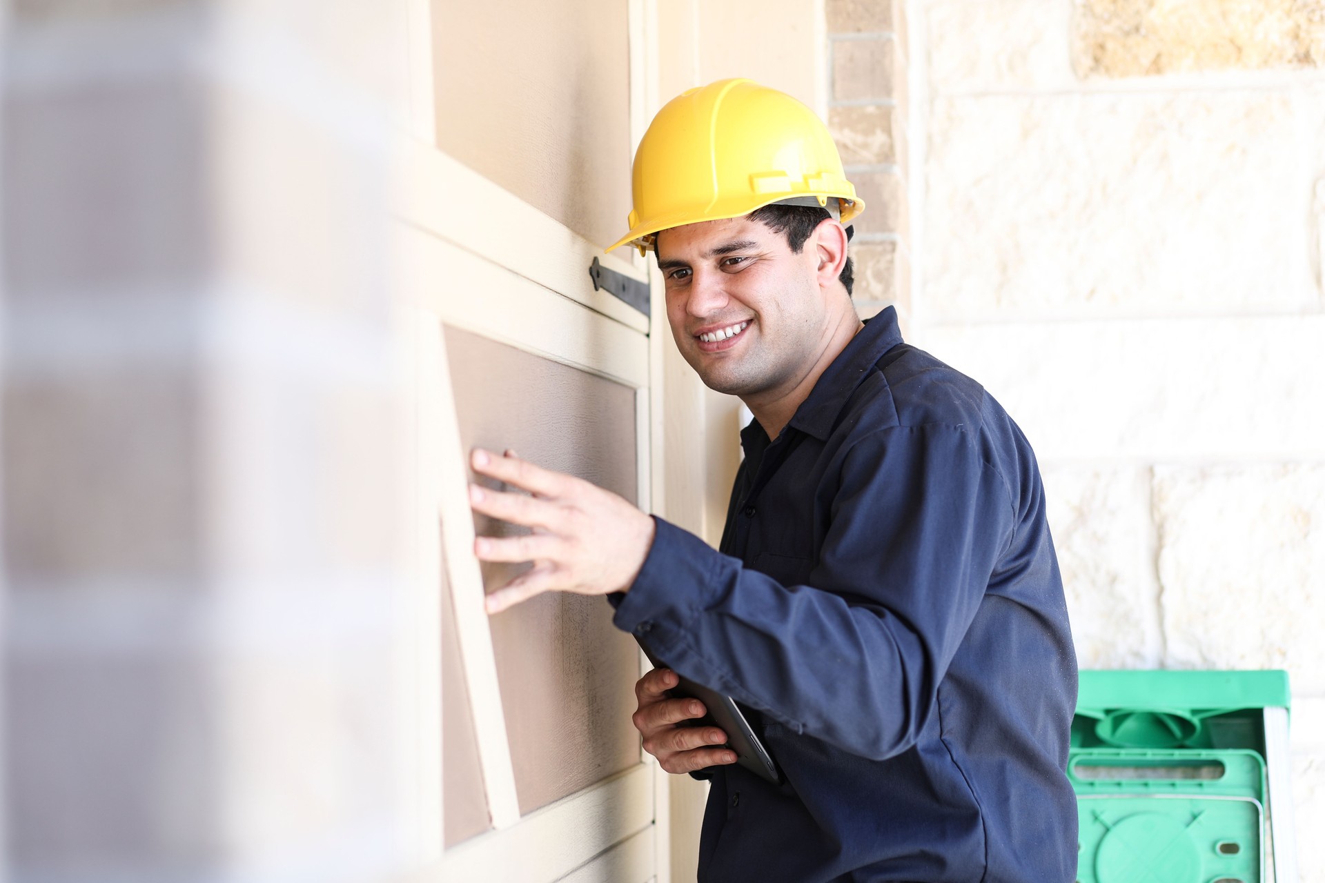 Latin descent man inspects home exterior. Contractor, inspector.