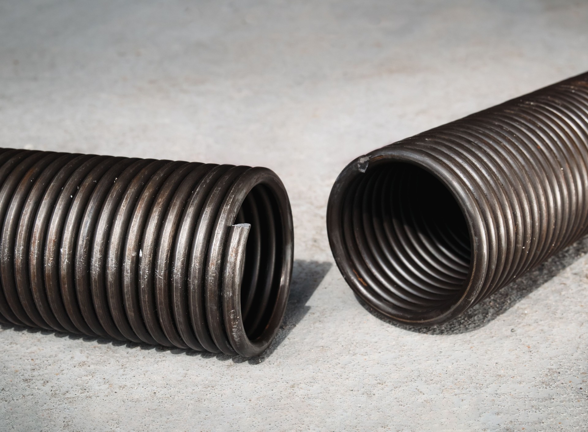 Broken garage gate spring or torsion spring from overhead sectional door.