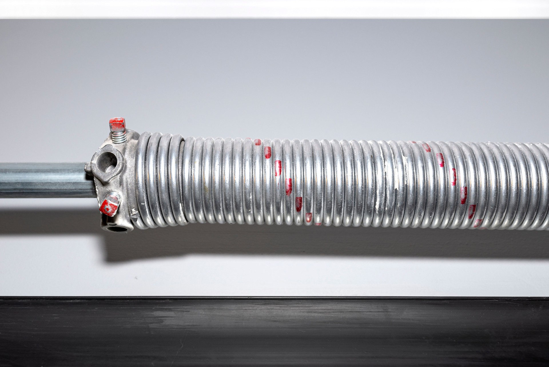 Springs tensioning the garage door mechanism, visible red spring and spring head.